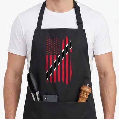 Souvenir trinidad and tobago apron - Distressed red white and black flag with vertical stripes and diagonal overlay — shown on a black cotton canvas apron against a white background