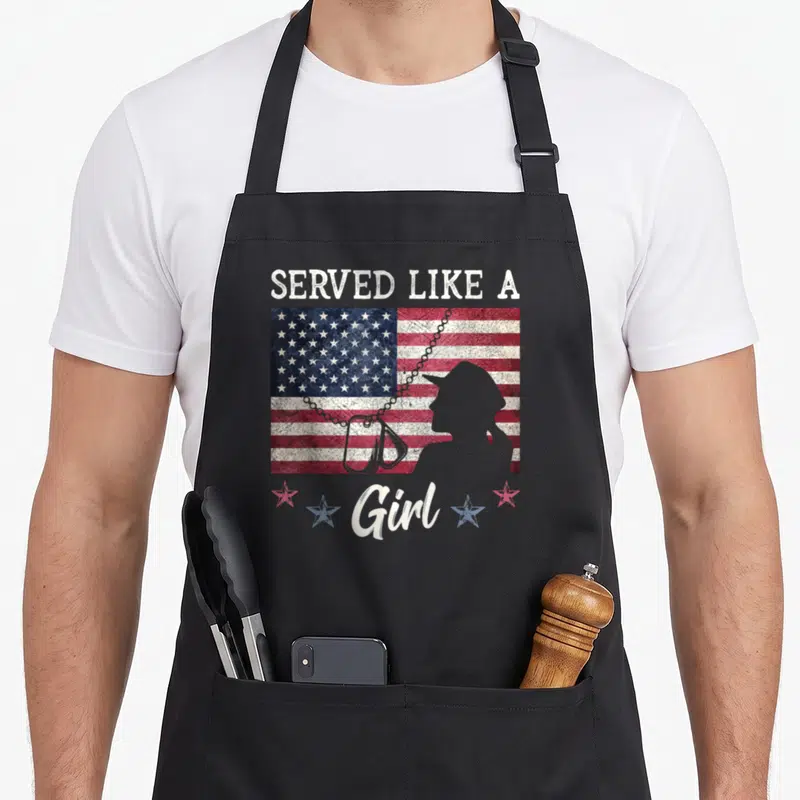 Served female veteran apron - Distressed USA flag with woman silhouette, dog tags, and four stars below text — shown on a black cotton canvas apron against a white background