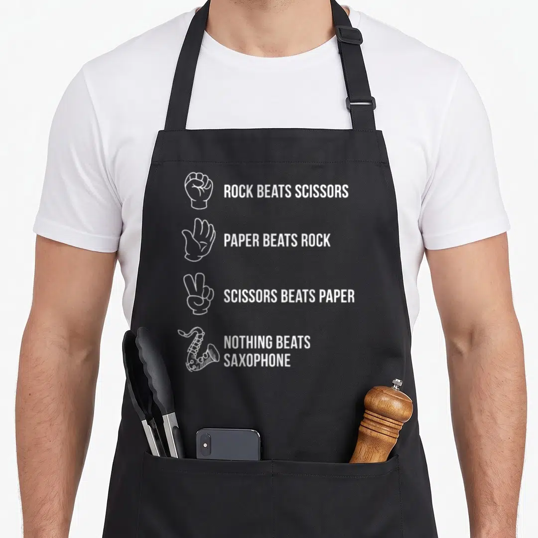 Cute saxophone apron - White line art of hands and saxophone with text declaring nothing beats saxophone — shown on a black cotton canvas apron against a white background