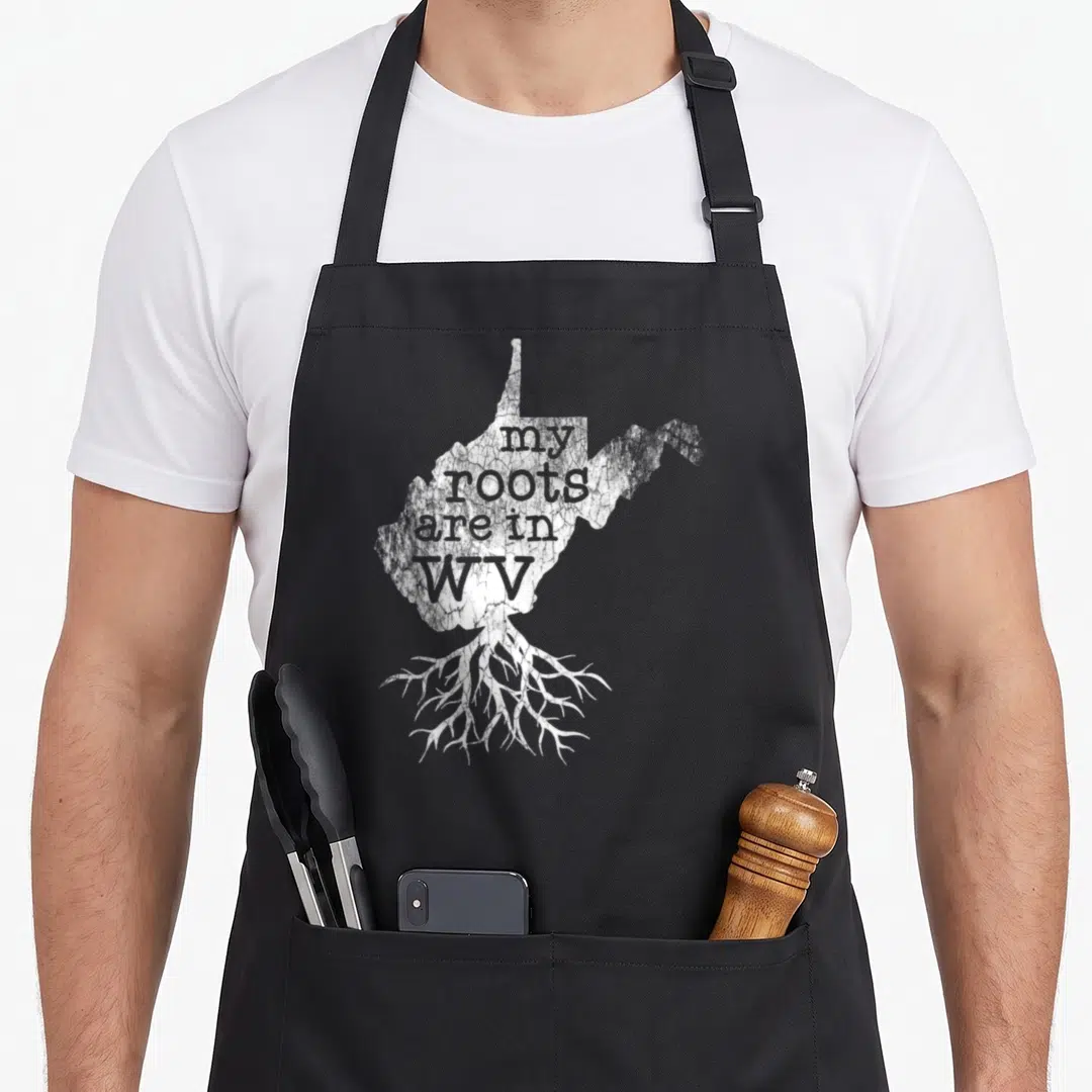 Root virginia girl apron - White distressed West Virginia map with roots and text my roots are in WV — shown on a black cotton canvas apron against a white background