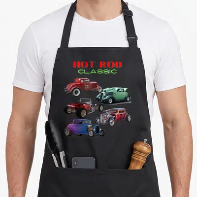 Car antique apron - Five realistic hot rod cars in red, green, purple, and blue below stacked HOT ROD CLASSIC text — shown on a black cotton canvas apron against a white background