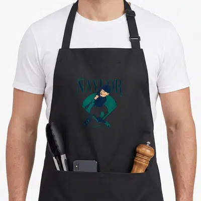Josh baseball apron - Cartoon baseball player swinging bat in front of teal diamond with text Josh NAYLOR — shown on a black cotton canvas apron against a white background
