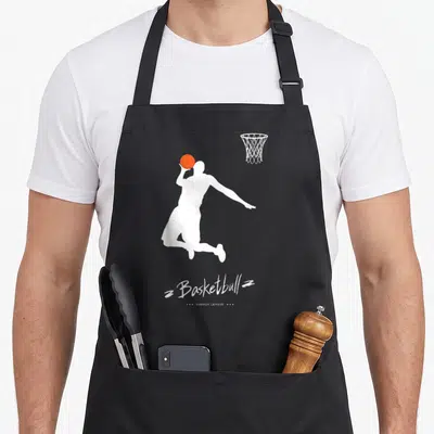 Basketball summer aprons - White jumping player silhouette holding orange ball with Basketball Summer League text — shown on a black cotton canvas apron against a white background