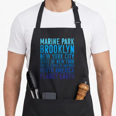 Marine new york apron - Stacked blue gradient text listing Marine Park Brooklyn New York City State USA North America — shown on a black cotton canvas apron against a white background