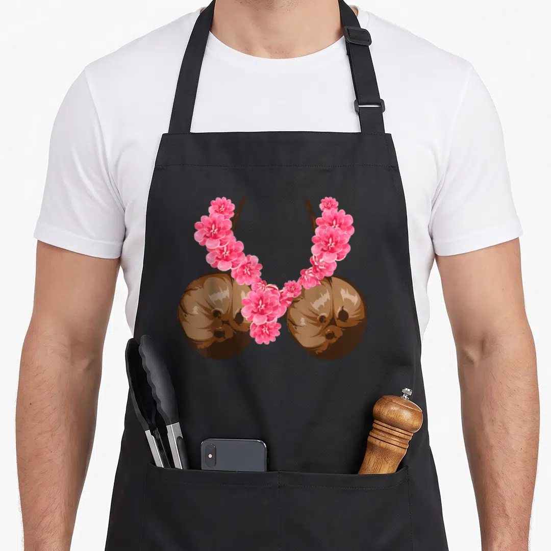 Hawaiian halloween apron - Two brown coconuts with pink flowers arching over them in watercolor style — shown on a black cotton canvas apron against a white background