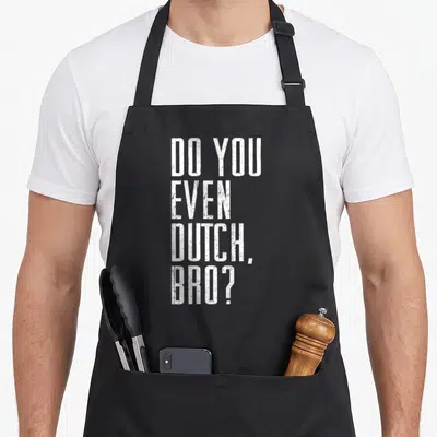 College joke apron - White stacked text DO YOU EVEN DUTCH BRO on dark background — shown on a black cotton canvas apron against a white background