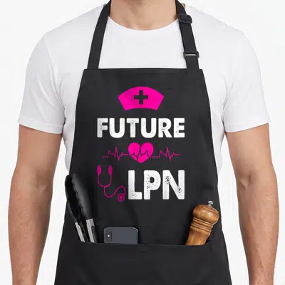 Appreciate nurse apron - Pink nurse cap FUTURE LPN heart stethoscope text on black — shown on a black cotton canvas apron against a white background