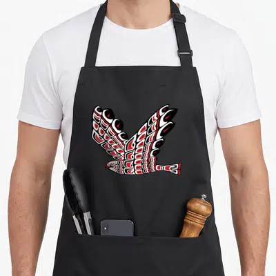 Pacific native american apron - Stylized eagle in flight with black red and white line art in indigenous style — shown on a black cotton canvas apron against a white background