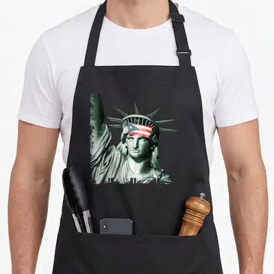 Puerto liberty apron - Statue of Liberty with Puerto Rican flag on forehead in green and red white blue — shown on a black cotton canvas apron against a white background
