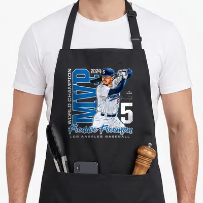 Champion mvp apron - Freddie Freeman baseball player graphic with 2024 MVP and World Champion text — shown on a black cotton canvas apron against a white background