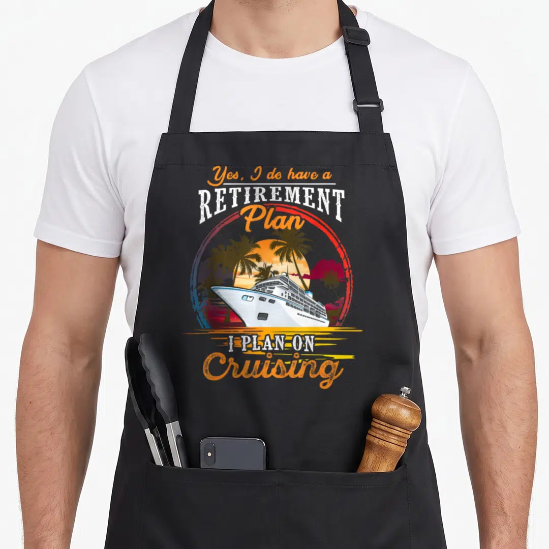 Cruising retirement apron - Retro cruise ship sunset graphic with Yes I do have a retirement plan text — shown on a black cotton canvas apron against a white background