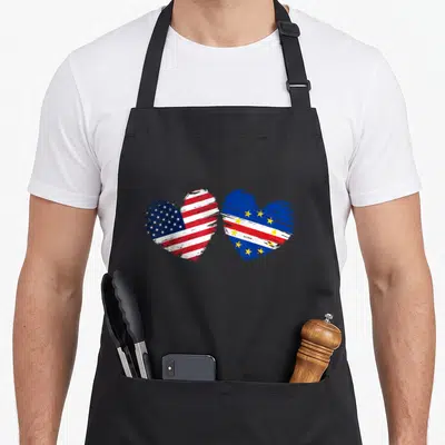 Cape valentine's day apron - Two hearts filled with US and Cape Verde flags in red white blue and yellow — shown on a black cotton canvas apron against a white background