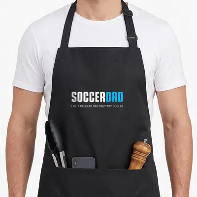 Soccer father dad apron - White and blue typography reading Soccer Dad Like a Regular Dad Only Way Cooler — shown on a black cotton canvas apron against a white background
