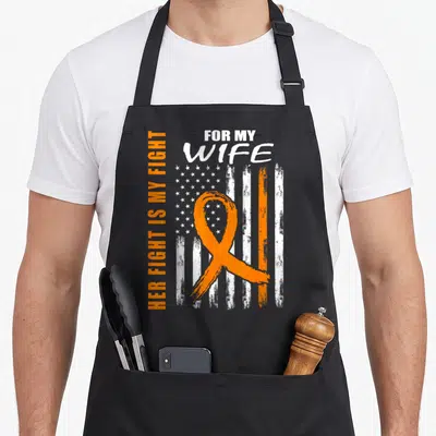 Fight kidney wife apron - Orange ribbon over distressed USA flag with vertical text FOR MY WIFE HER FIGHT IS MY FIGHT — shown on a black cotton canvas apron against a white background