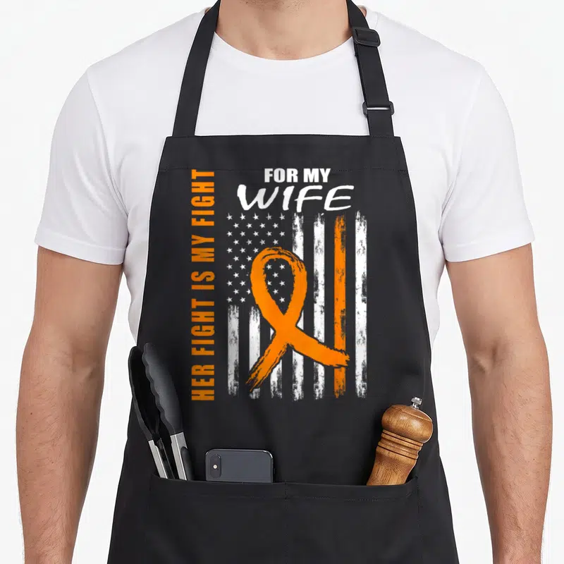 Fight kidney wife apron - Orange ribbon over distressed USA flag with vertical text FOR MY WIFE HER FIGHT IS MY FIGHT — shown on a black cotton canvas apron against a white background