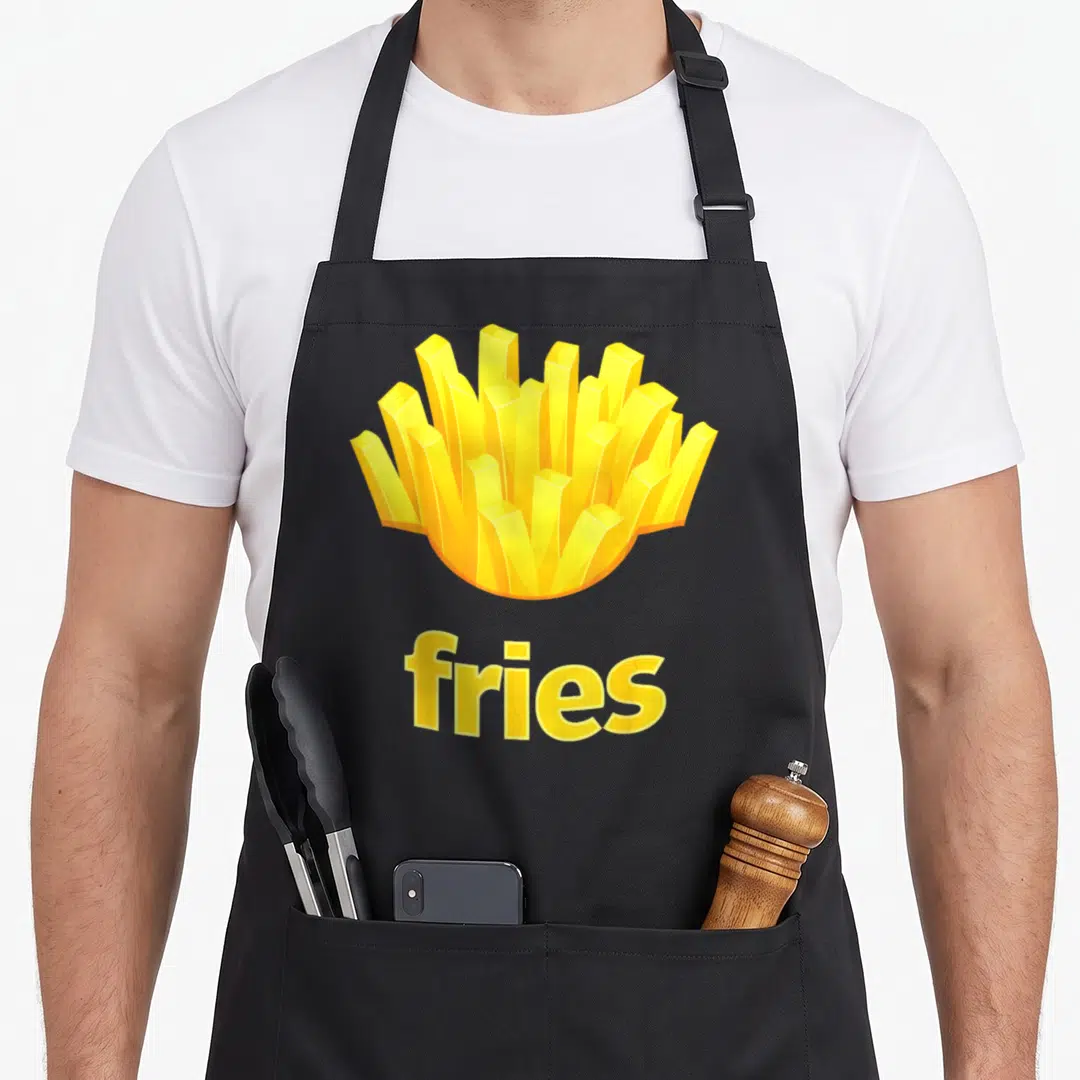 French halloween apron - Cartoon yellow and orange fries cluster above the word fries on a black background — shown on a black cotton canvas apron against a white background