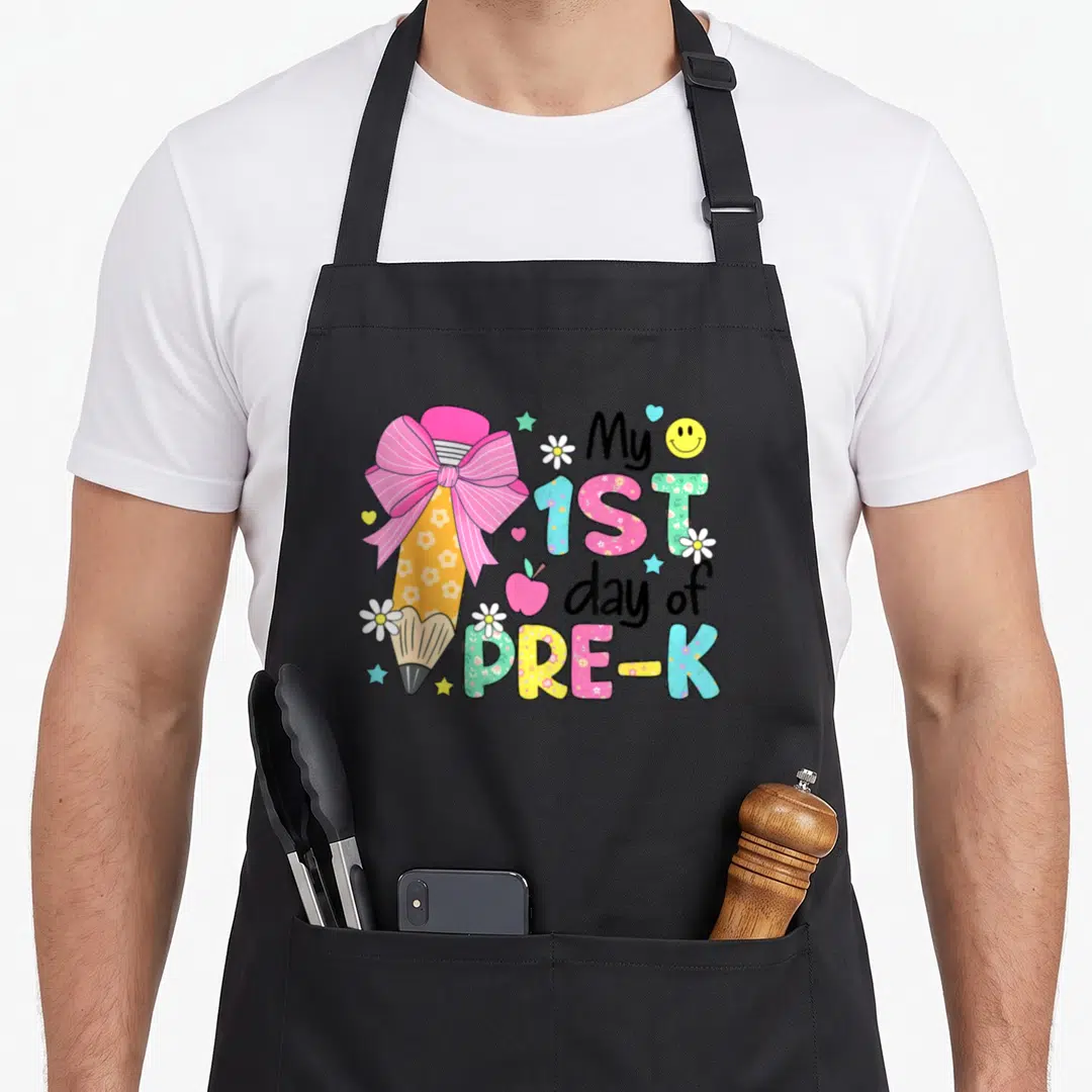 1st pre k back apron - Yellow pencil with pink bow and My 1ST day of PRE-K text in floral patterns — shown on a black cotton canvas apron against a white background