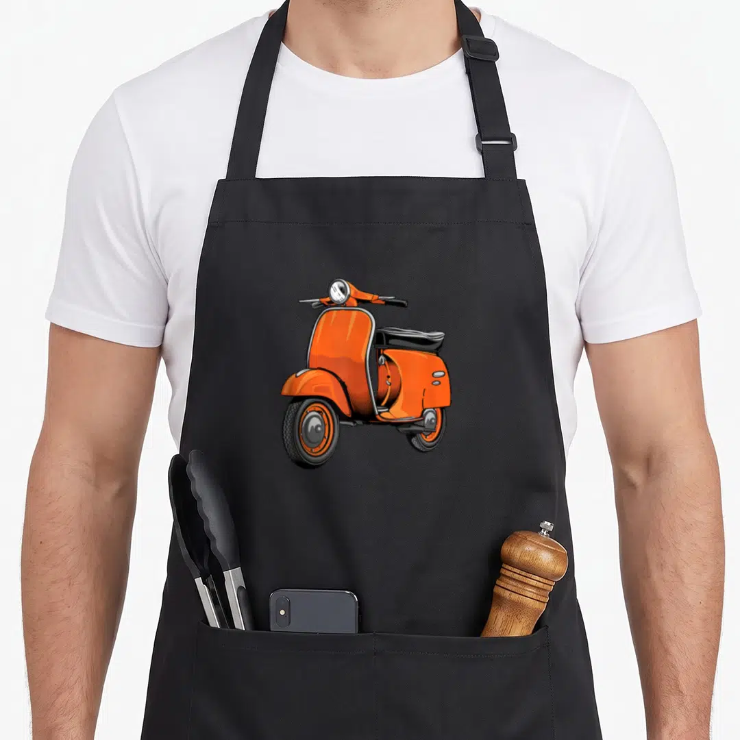 Scooter bike apron - Realistic orange vintage scooter illustration with black seat and wheels — shown on a black cotton canvas apron against a white background