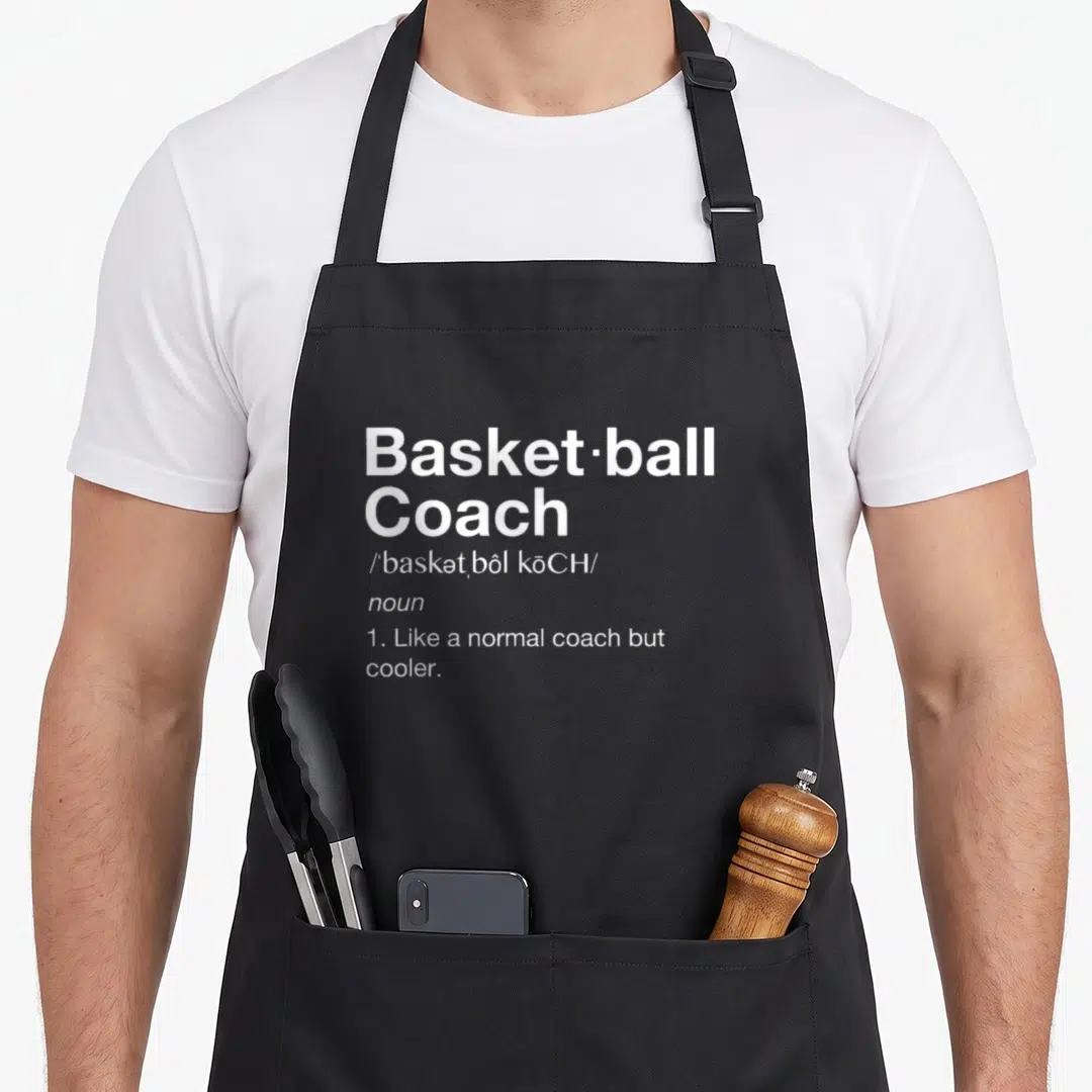 Definition basketball coach apron - White dictionary definition text reading Basketball Coach Like a normal coach — shown on a black cotton canvas apron against a white background