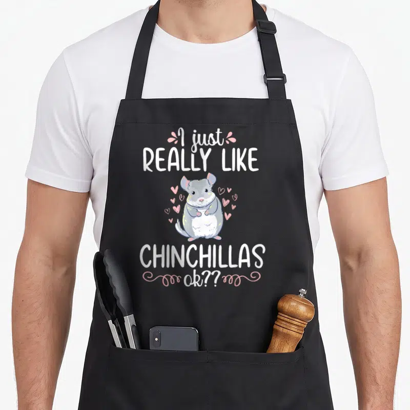 Chinchilla pet animal apron - Cartoon grey chinchilla with pink hearts and white text reading I just really like — shown on a black cotton canvas apron against a white background