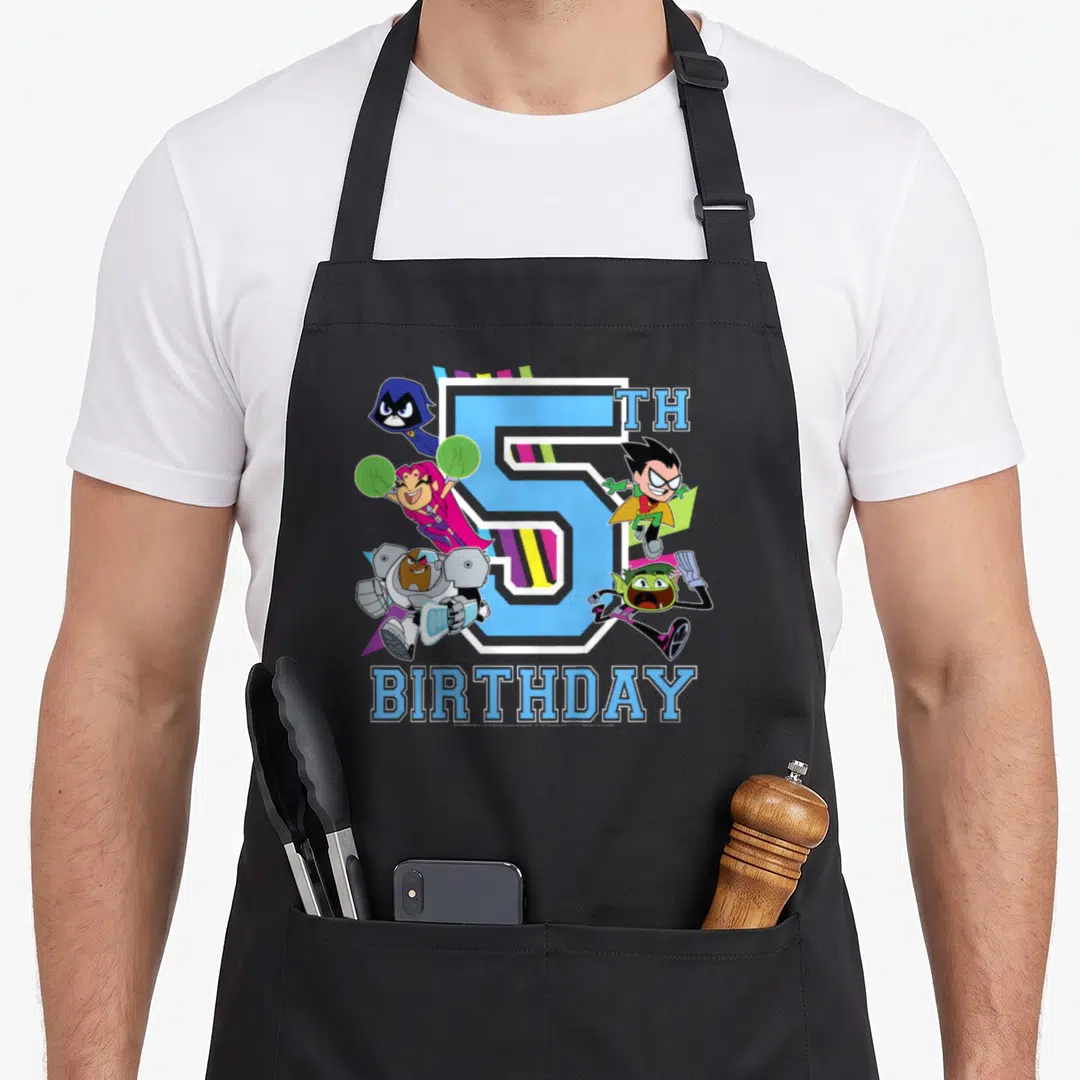 Funny 5th birthday apron - Blue number 5 with five cartoon characters and diagonal stripes in green purple pink — shown on a black cotton canvas apron against a white background
