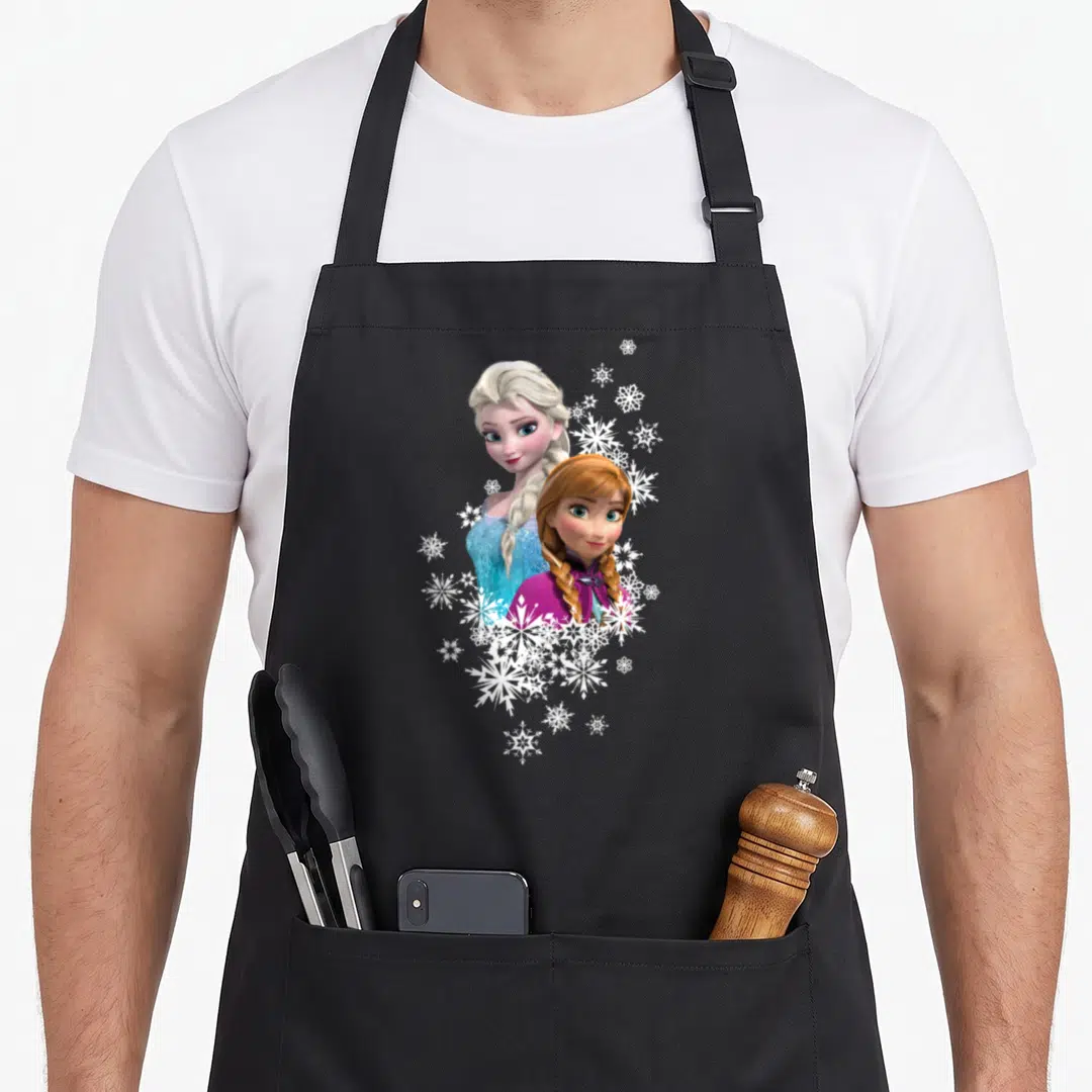 Anna frozen apron - Elsa and Anna portrait with white snowflake cluster in blue and magenta photo art — shown on a black cotton canvas apron against a white background