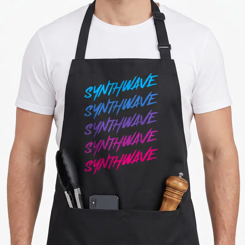 Synthesizer 80s apron - Stacked SYNTHWAVE text in blue purple and pink gradient typography — shown on a black cotton canvas apron against a white background