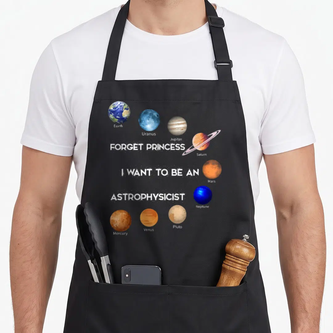 Retro forget princess apron - Planets including Saturn and Mars surround stacked white text reading Forget Princess I — shown on a black cotton canvas apron against a white background