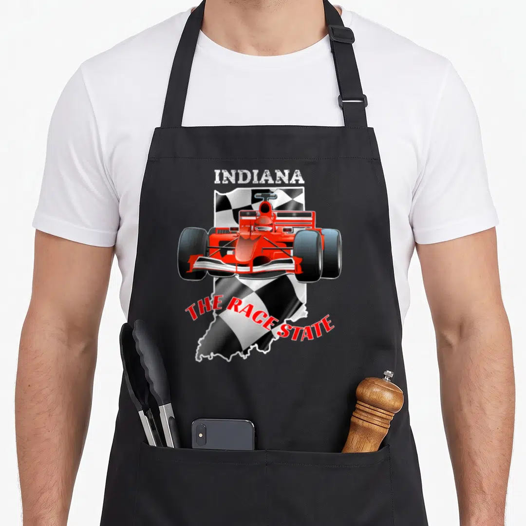 Indianapolis checkered apron - Red race car over checkered Indiana state shape with INDIANA and THE RACE STATE text — shown on a black cotton canvas apron against a white background