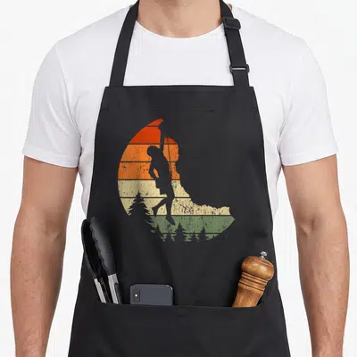 Climber climbing apron - Grey golfer silhouette on red orange and green striped circle — shown on a black cotton canvas apron against a white background