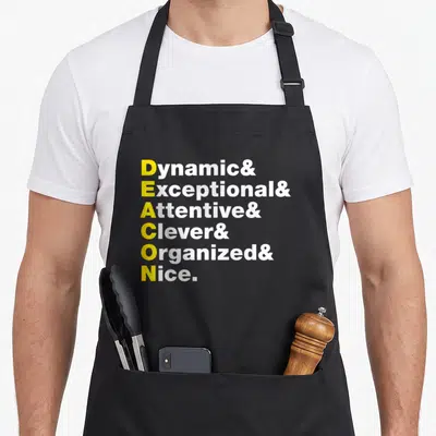 Cute deacon apron - Yellow and white text stack spelling Deacon via Dynamic Exceptional Attentive Clever Organized Nice — shown on a black cotton canvas apron against a white background