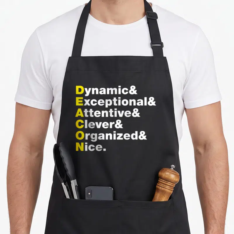 Cute deacon apron - Yellow and white text stack spelling Deacon via Dynamic Exceptional Attentive Clever Organized Nice — shown on a black cotton canvas apron against a white background