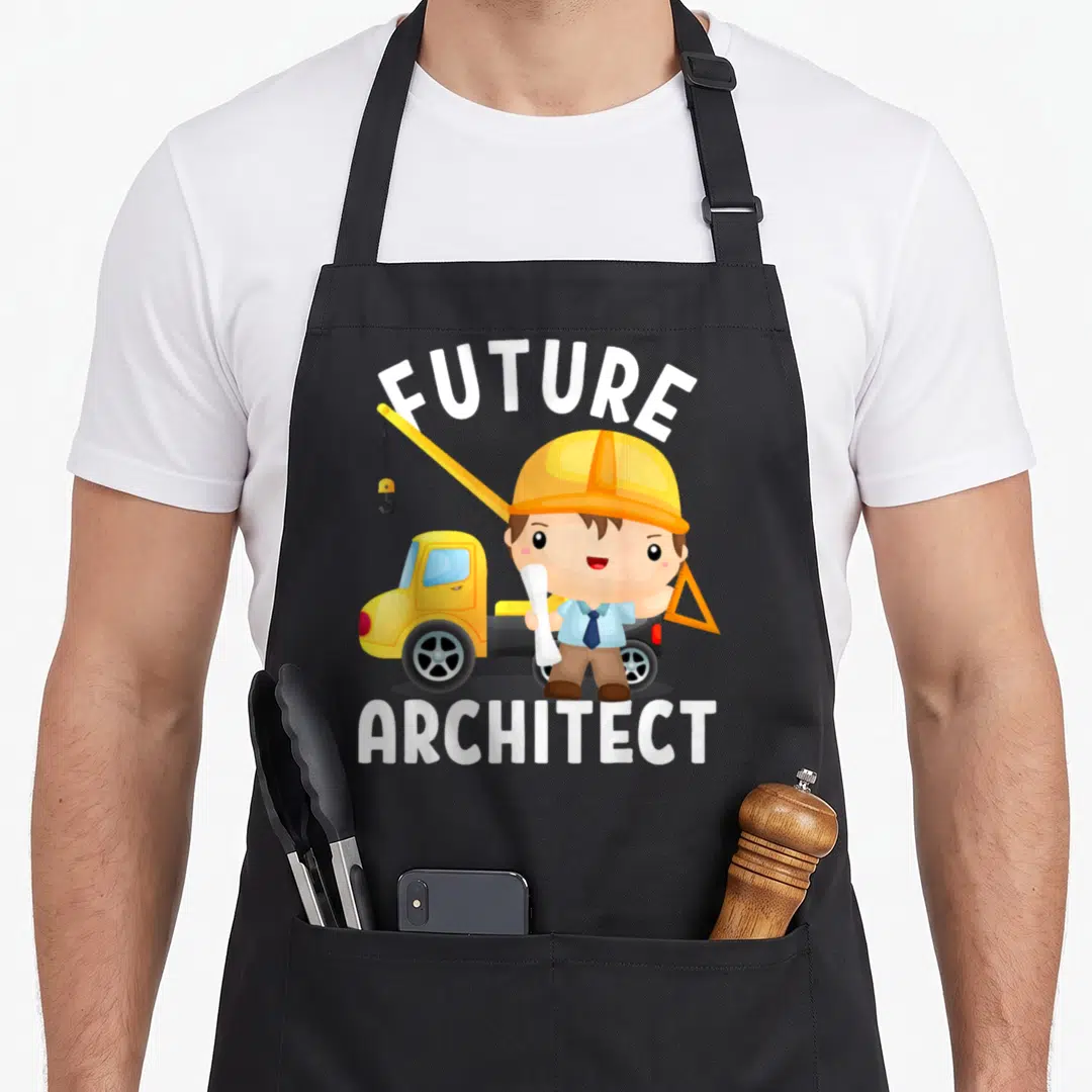 Future architect apron - Cartoon boy in yellow hard hat holding plans near yellow crane truck with white text — shown on a black cotton canvas apron against a white background