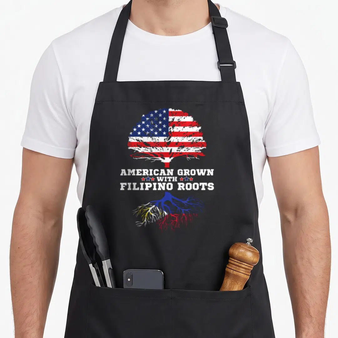Philippine boeuf bourguignon apron - Tree with US flag canopy and Philippine flag roots surrounding stacked white text — shown on a black cotton canvas apron against a white background