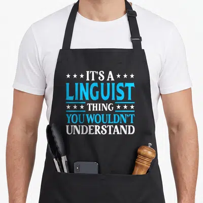 Linguist employee aprons - Blue and white stacked text IT'S A LINGUIST THING flanked by rows of three stars — shown on a black cotton canvas apron against a white background
