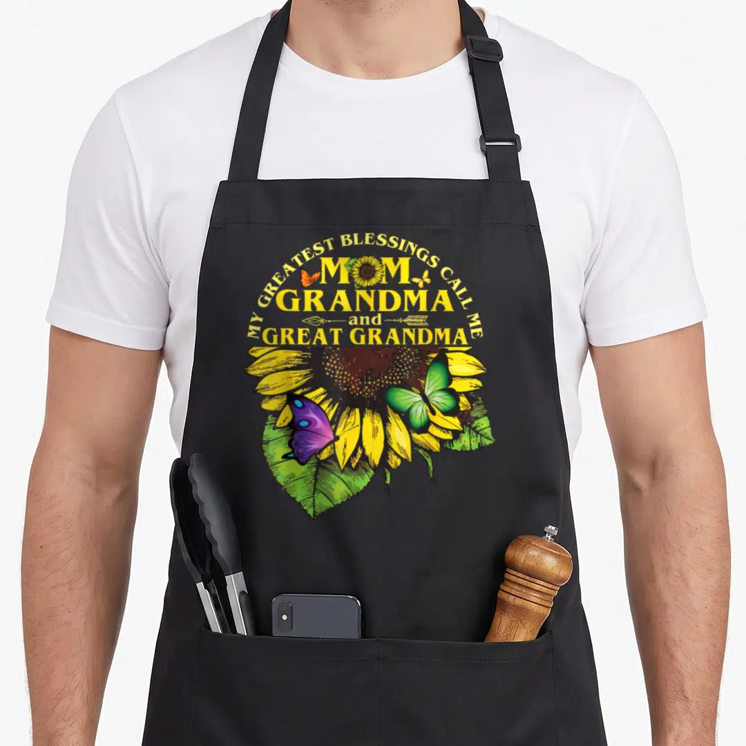 Greatest great grandma apron - Sunflower and purple butterfly graphic with Mom Grandma Great Grandma text — shown on a black cotton canvas apron against a white background