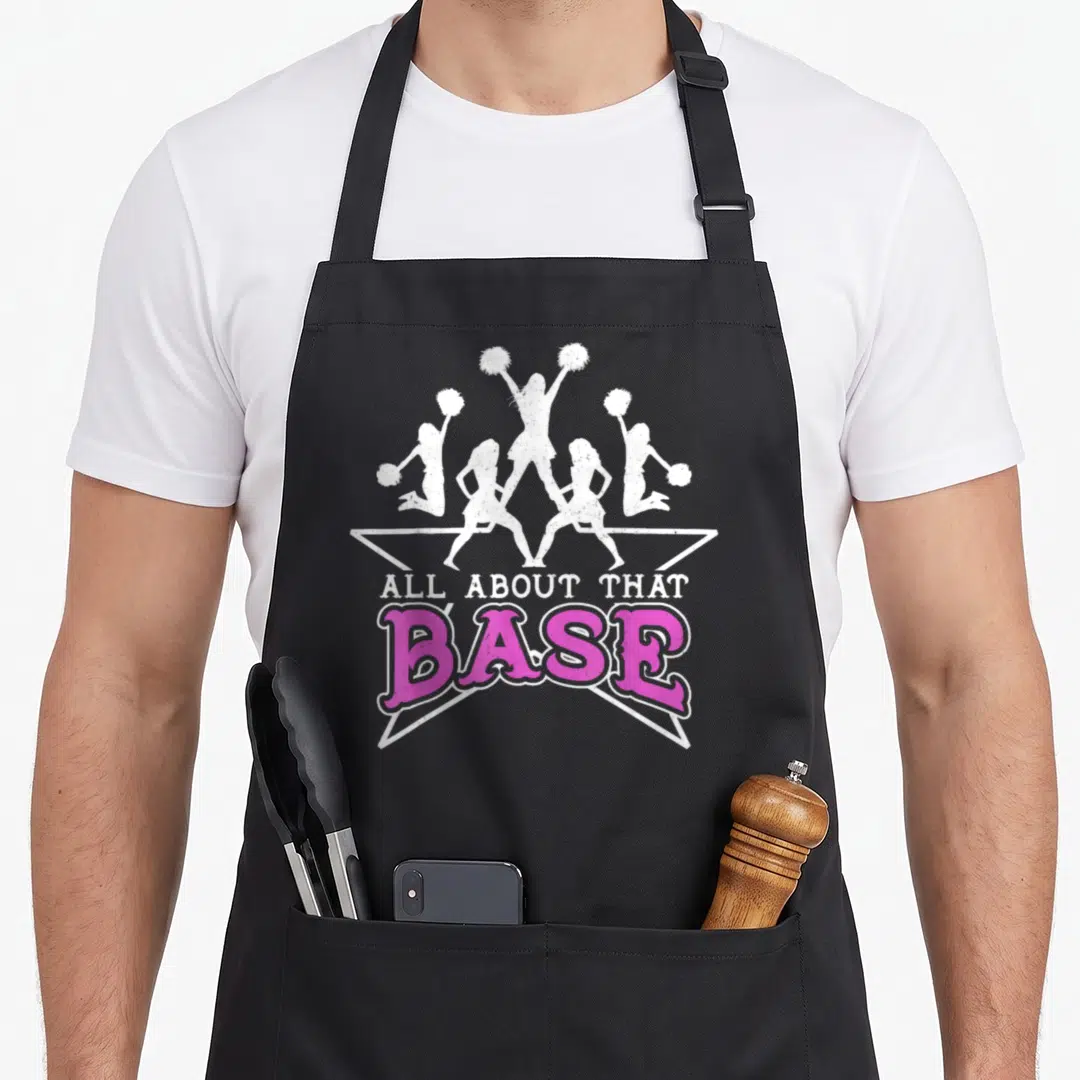 Base cheerleading apron - Five white cheerleader silhouettes above pink and white ALL ABOUT THAT BASE text — shown on a black cotton canvas apron against a white background