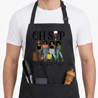 Sip wine apron - Four women with suitcases under OH SIP text and wine glass replacing the letter I — shown on a black cotton canvas apron against a white background