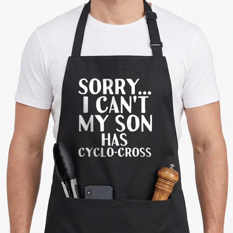 Cyclo cross apron - White stacked text reading Sorry I Can't My Son Has Cyclo-cross on grey background — shown on a black cotton canvas apron against a white background