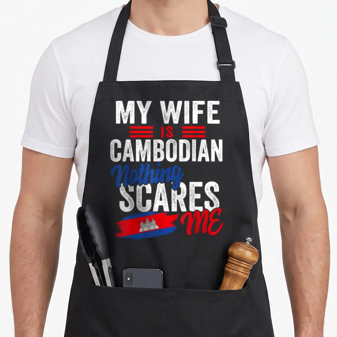 Cambodia wife apron - Stacked white red and blue text My Wife Is Cambodian Nothing Scares Me with brush stroke flag — shown on a black cotton canvas apron against a white background