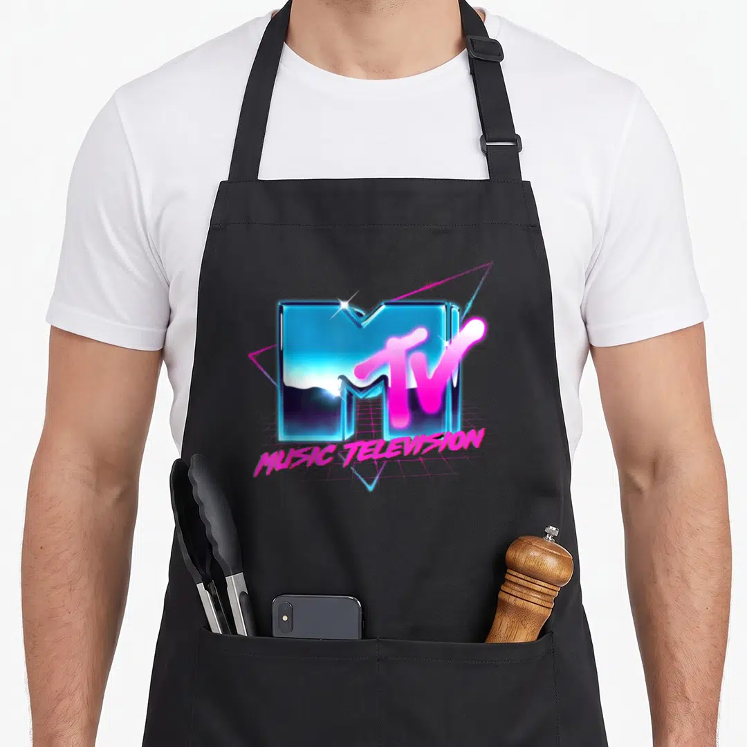 Effect 80s apron - Blue 3D MTV logo with pink TV overlay and MUSIC TELEVISION text on pink grid — shown on a black cotton canvas apron against a white background