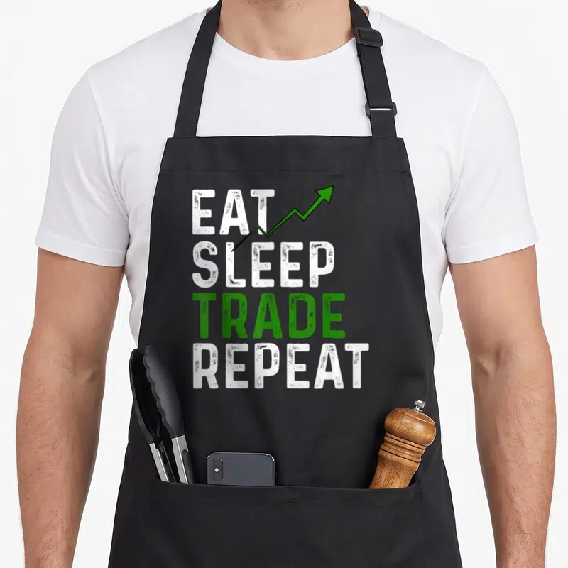 Trading stock aprons - EAT SLEEP TRADE REPEAT text with green upward arrow on white background — shown on a black cotton canvas apron against a white background