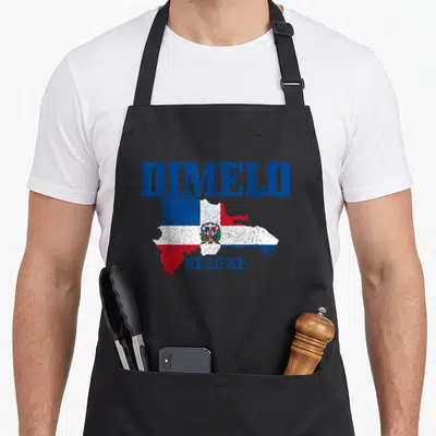 Dimelo dominican pride apron - Distressed map of Dominican Republic filled with flag colors, DIMELO above, KE LO KE — shown on a black cotton canvas apron against a white background