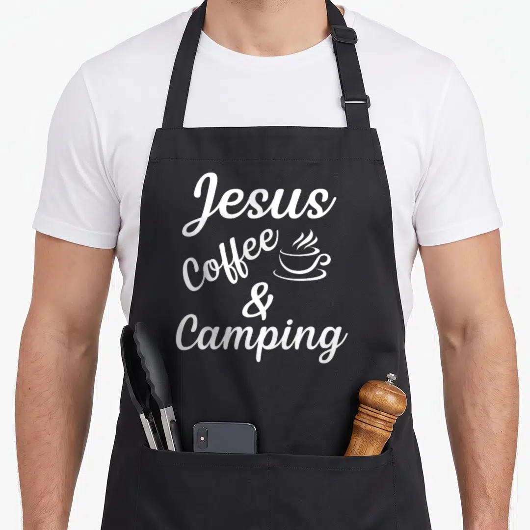 Jesus camping apron - White stacked text Jesus Coffee & Camping with small steaming cup icon beside Coffee — shown on a black cotton canvas apron against a white background