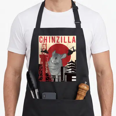 Funny chinzilla chinchilla lover apron - Retro print of giant grey chinchilla head over red sun with tower — shown on a black cotton canvas apron against a white background