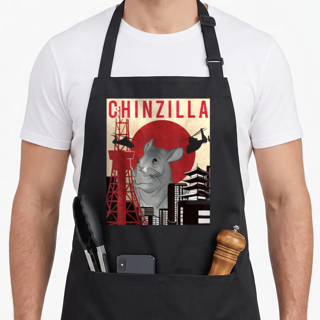 Funny chinzilla chinchilla lover apron - Retro print of giant grey chinchilla head over red sun with tower — shown on a black cotton canvas apron against a white background