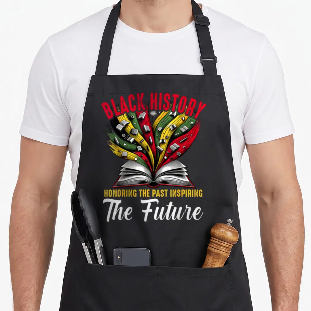 Honoring future teacher apron - Open book with red yellow green and black streams holding books and a globe under BLACK — shown on a black cotton canvas apron against a white background