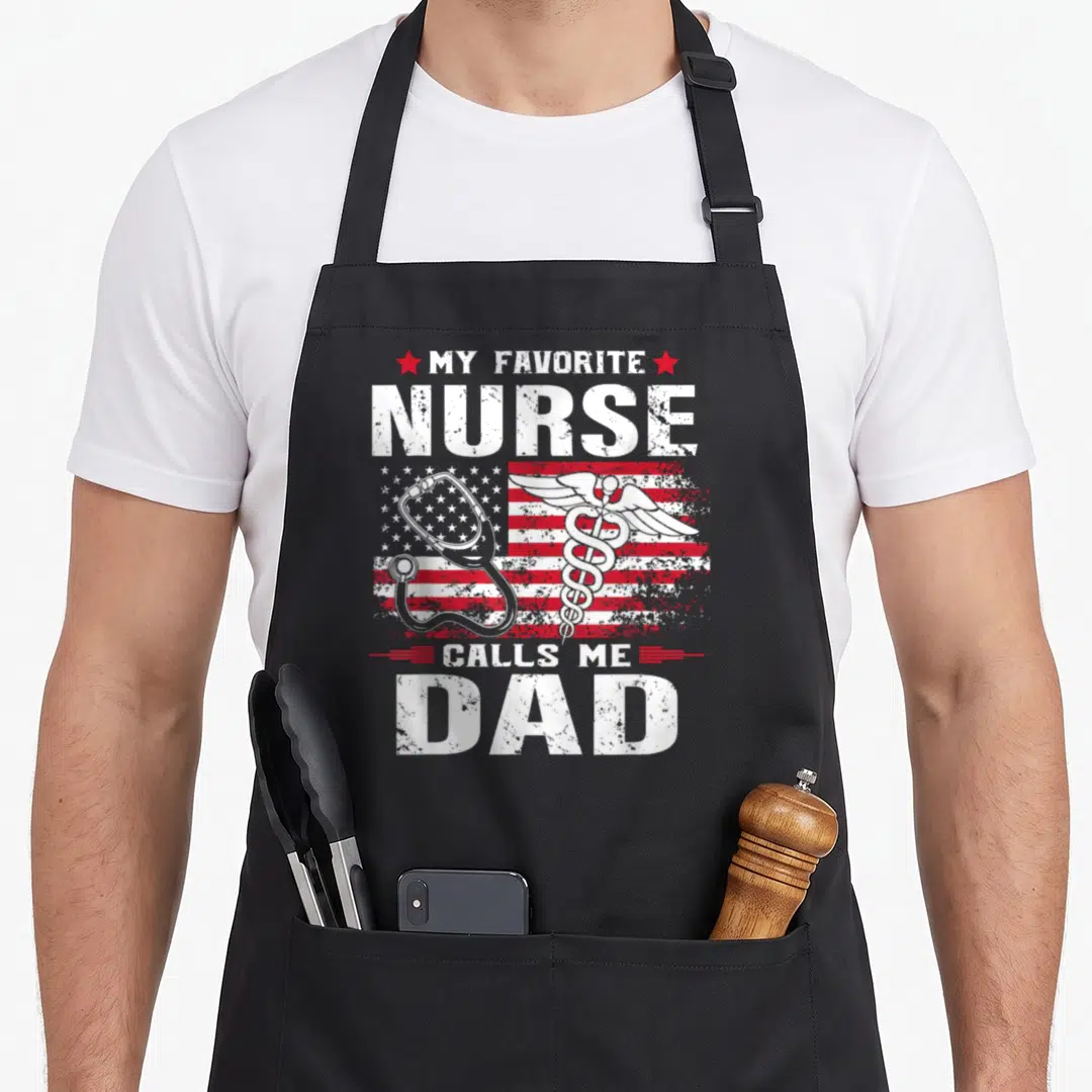 Call flag nurses apron - My Favorite Nurse Calls Me Dad text with caduceus and stethoscope on distressed flag — shown on a black cotton canvas apron against a white background