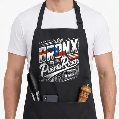 Puerto new york apron - Retro BRONX text with flag fill, Puerto Rican script, and 8P subway train graphic — shown on a black cotton canvas apron against a white background