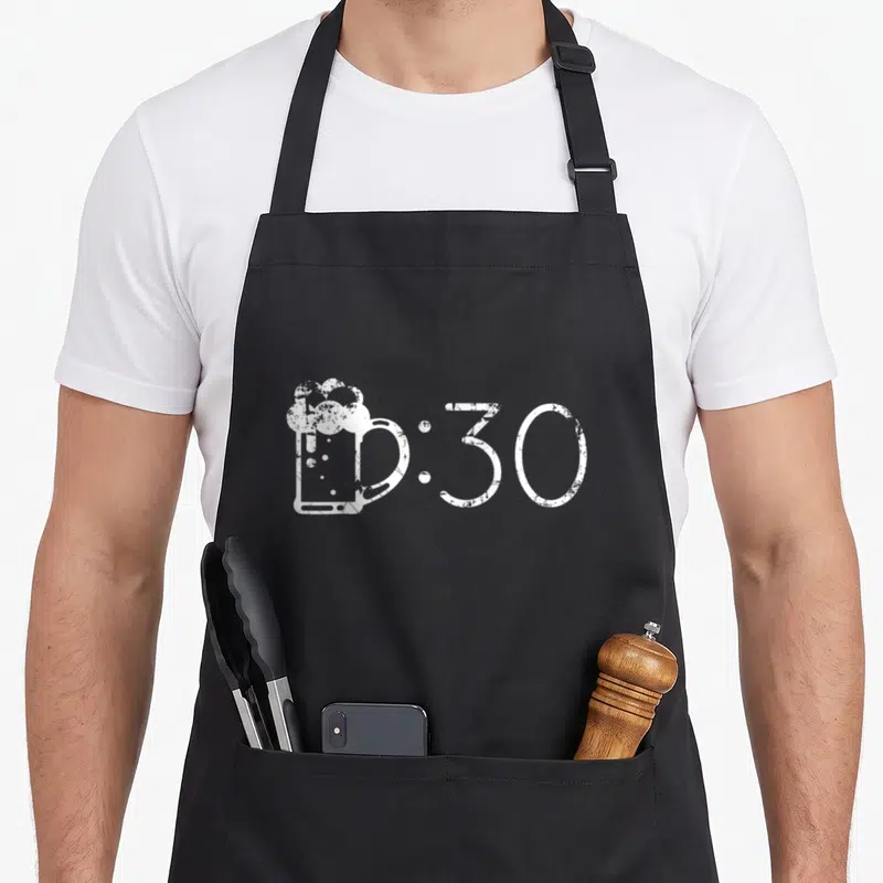 Drinker beer apron - White distressed beer mug icon next to :30 text on dark background — shown on a black cotton canvas apron against a white background